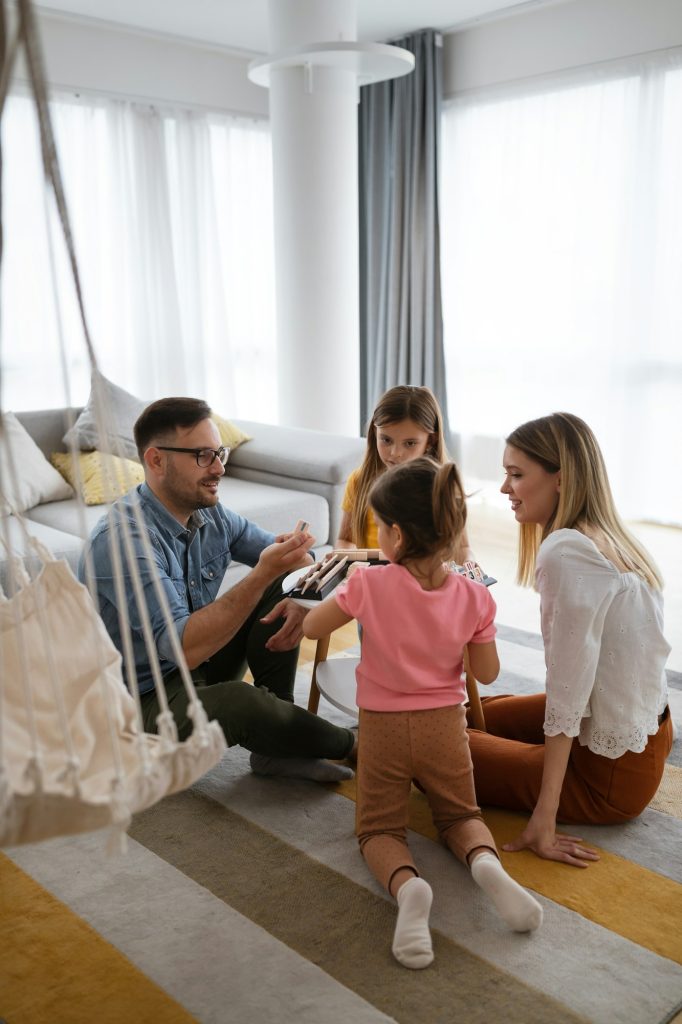 Familia jugando con sus hijos en casa, felices y seguros.